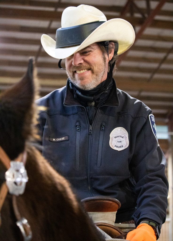 Seattle Mounted Patrol Officer on a horse smiling with a cowboy hat on