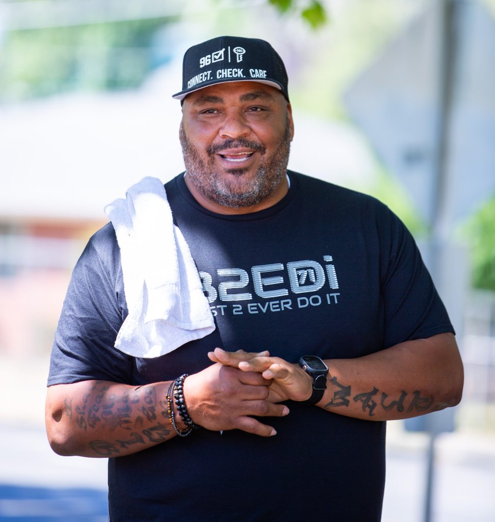 Former Seattle Seahawk Walter Jones standing in a park with a white towel over his shoulder