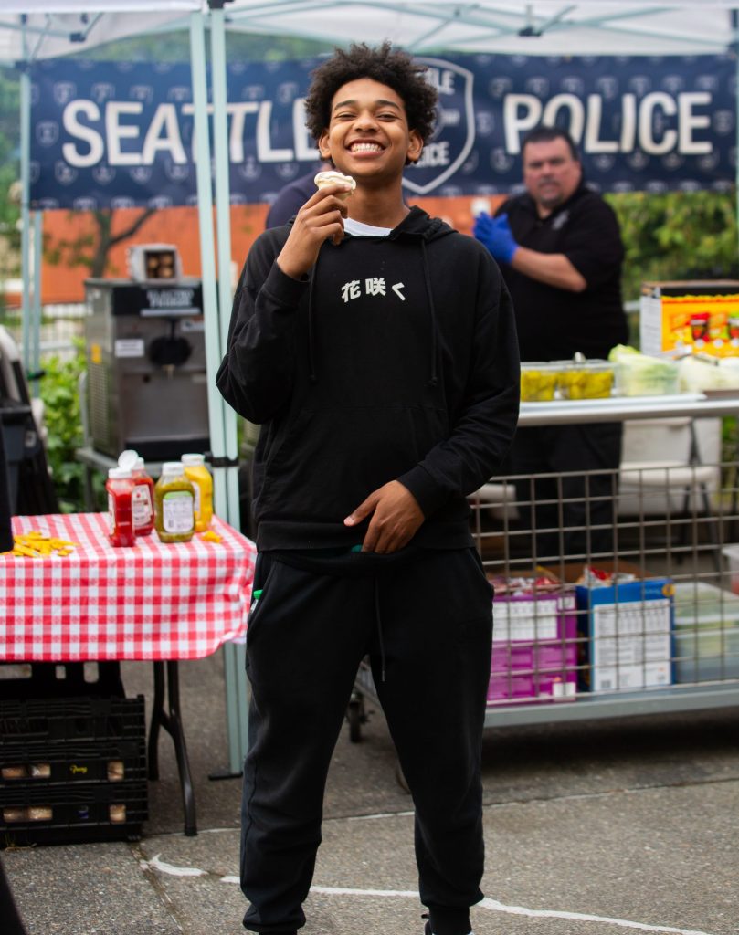 Young man wearing black a sweatsuit eating an ice cream cone